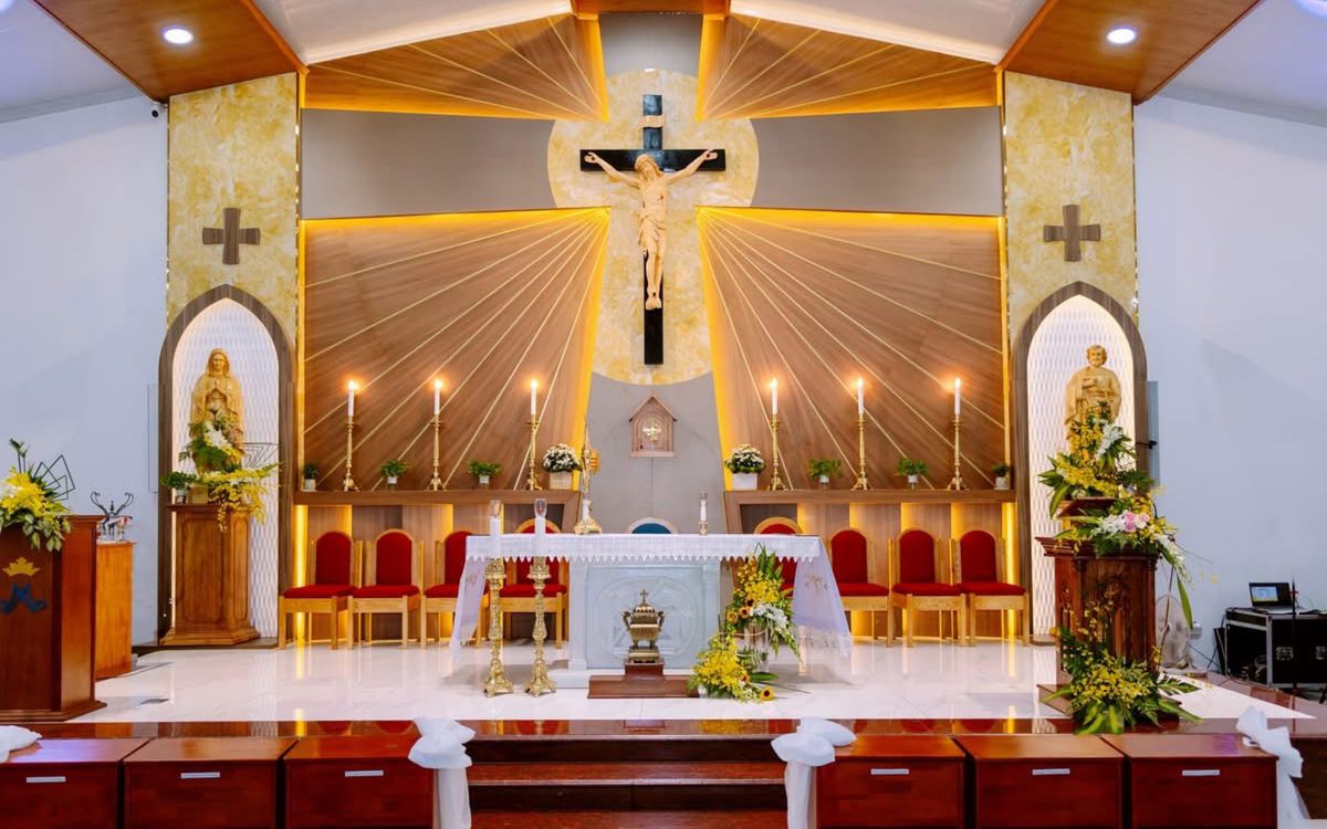 Beautifully decorated church altar with candles and religious statues, ready for ceremony.