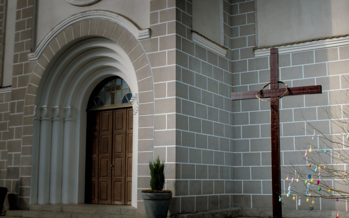 Beautiful church entrance with a wooden cross, representing faith and peace.