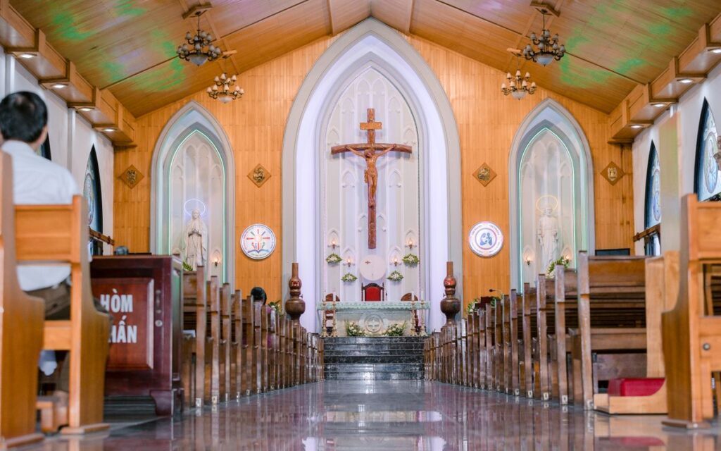A peaceful church interior showcasing rows of pews and a central altar with a crucifix.