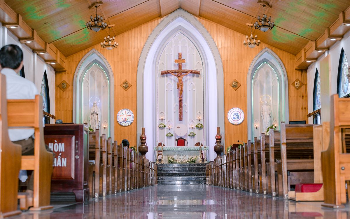 A peaceful church interior showcasing rows of pews and a central altar with a crucifix.