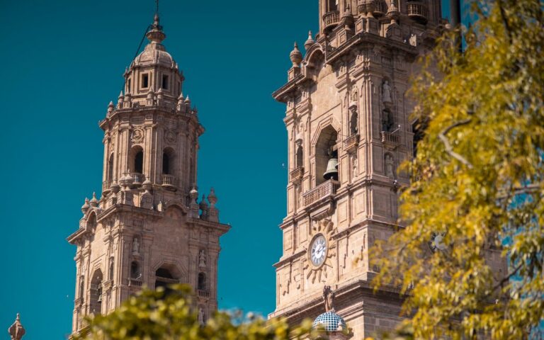 Baroque architecture of the Morelia Cathedral towers against a clear blue sky.