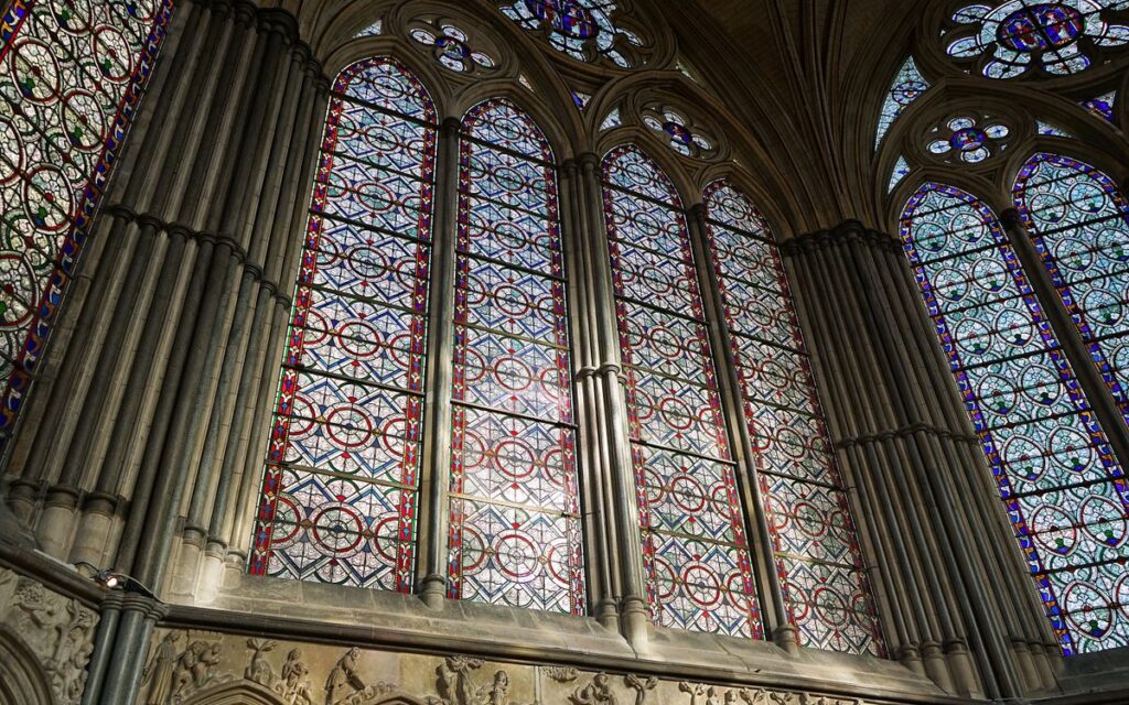Intricate stained glass windows in Salisbury Cathedral, showcasing Gothic architecture.
