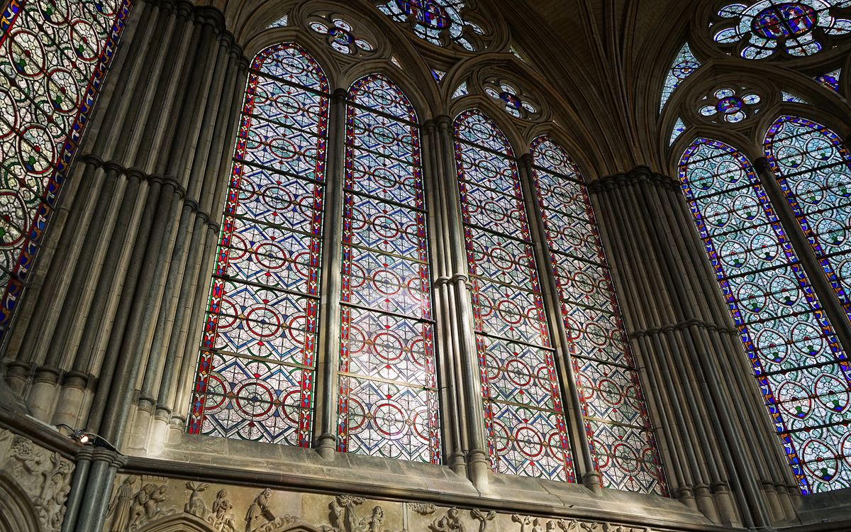 Intricate stained glass windows in Salisbury Cathedral, showcasing Gothic architecture.