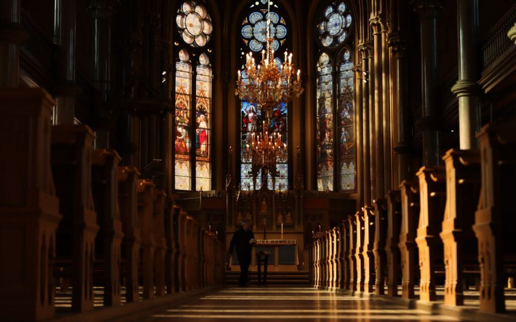 Beautiful church interior in Norrköping, Sweden featuring stained glass windows and ornate chandeliers.