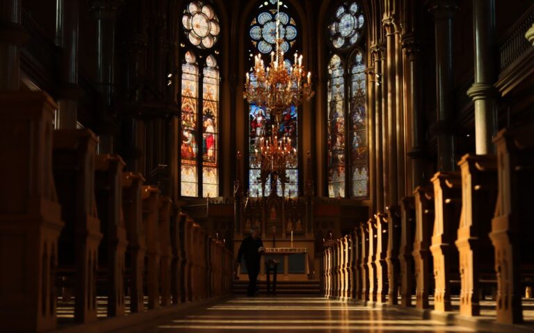 Beautiful church interior in Norrköping, Sweden featuring stained glass windows and ornate chandeliers.