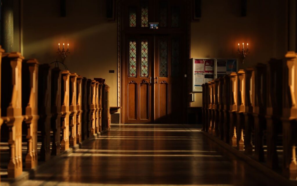 Sunlight streaming through stained glass in a Swedish church creates dramatic shadows and highlights.