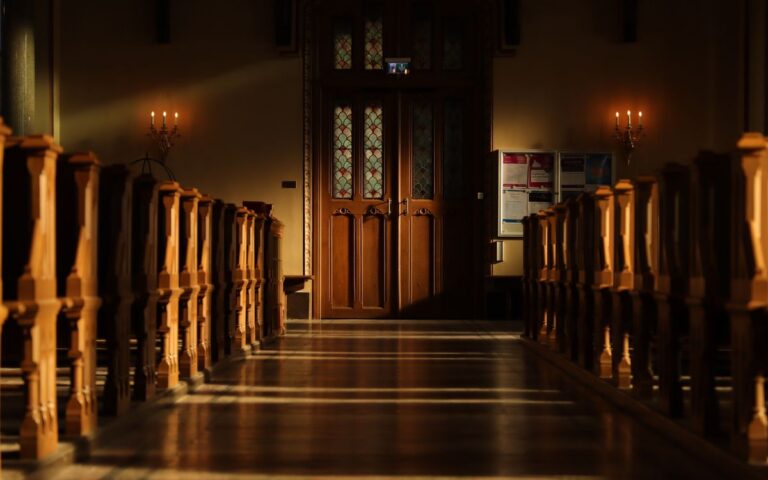 Sunlight streaming through stained glass in a Swedish church creates dramatic shadows and highlights.