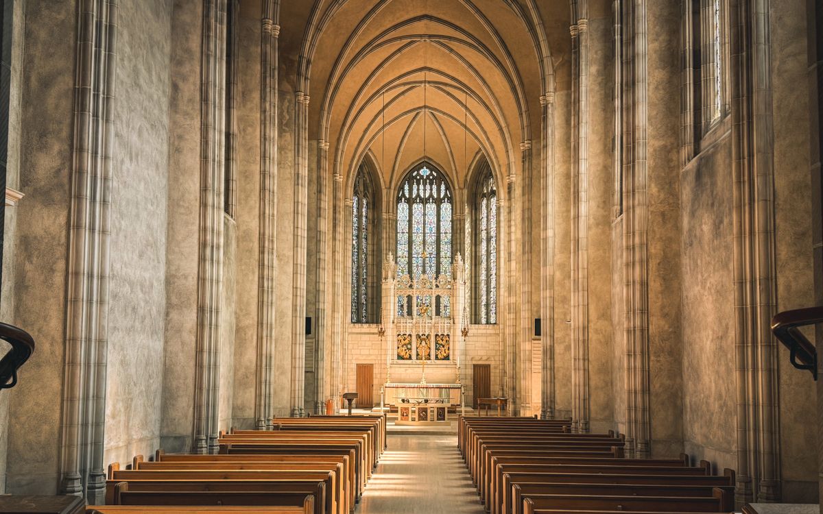Serene Gothic cathedral interior with sun-drenched altar and empty pews in Toronto.