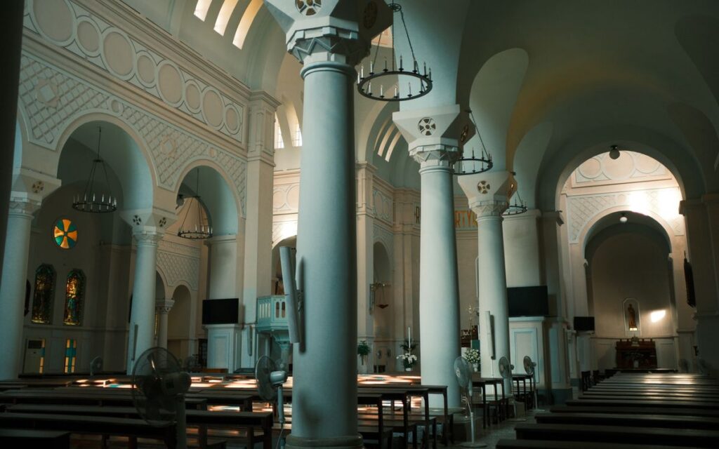 Interior view of a historic church with arches and columns, capturing serene architecture.