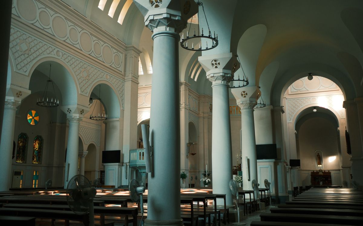 Interior view of a historic church with arches and columns, capturing serene architecture.