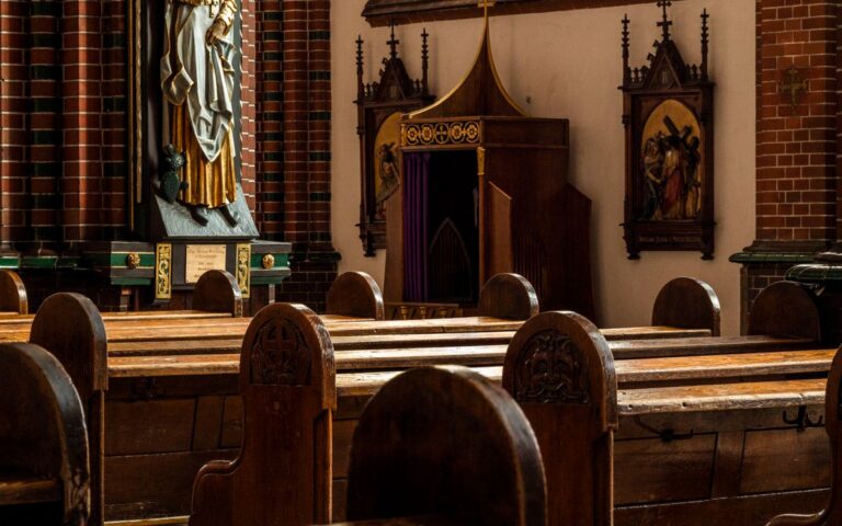 Elegant church interior featuring wooden pews and religious sculptures.