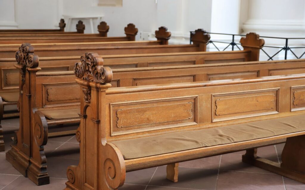 Detailed view of ornate wooden benches inside a church in Fulda, Germany, showcasing craftsmanship.