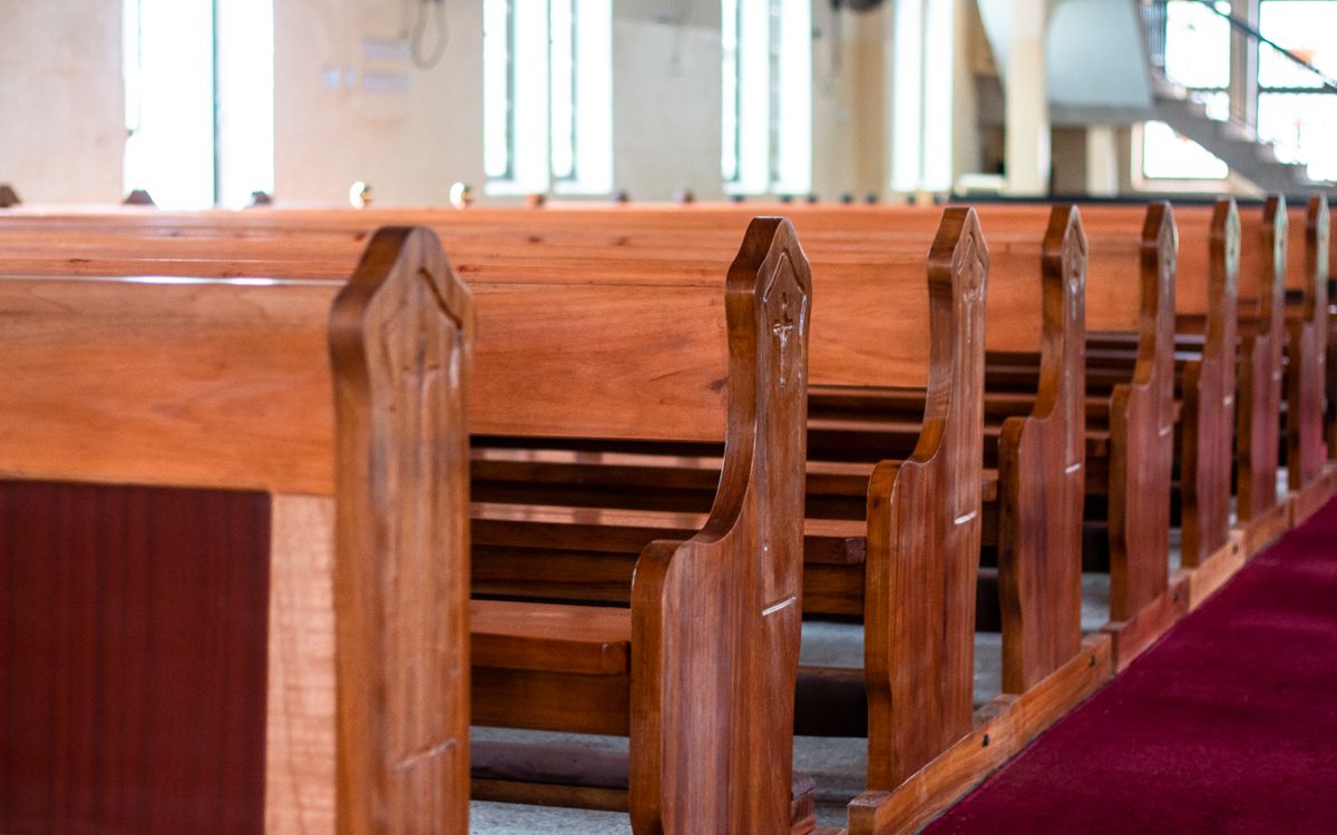 Elegant wooden church pews line an empty church in Ghana, creating a serene and sacred atmosphere.