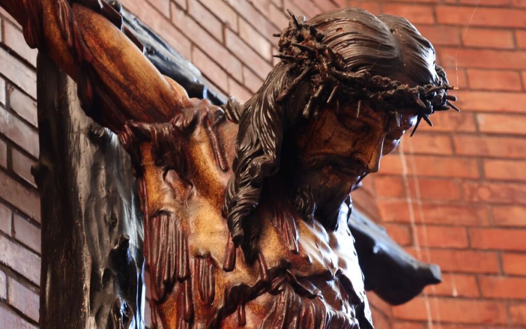 A close-up view of a wooden crucifix depicting Jesus Christ with a crown of thorns inside a historic church.