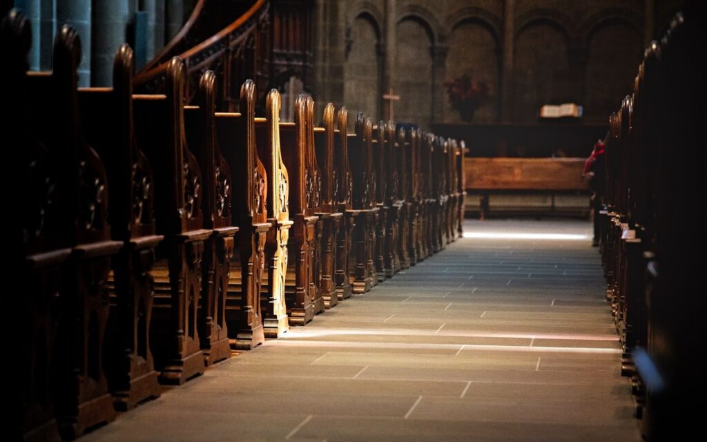 A tranquil view of ornate wooden pews inside an ancient church, emphasizing spirituality.