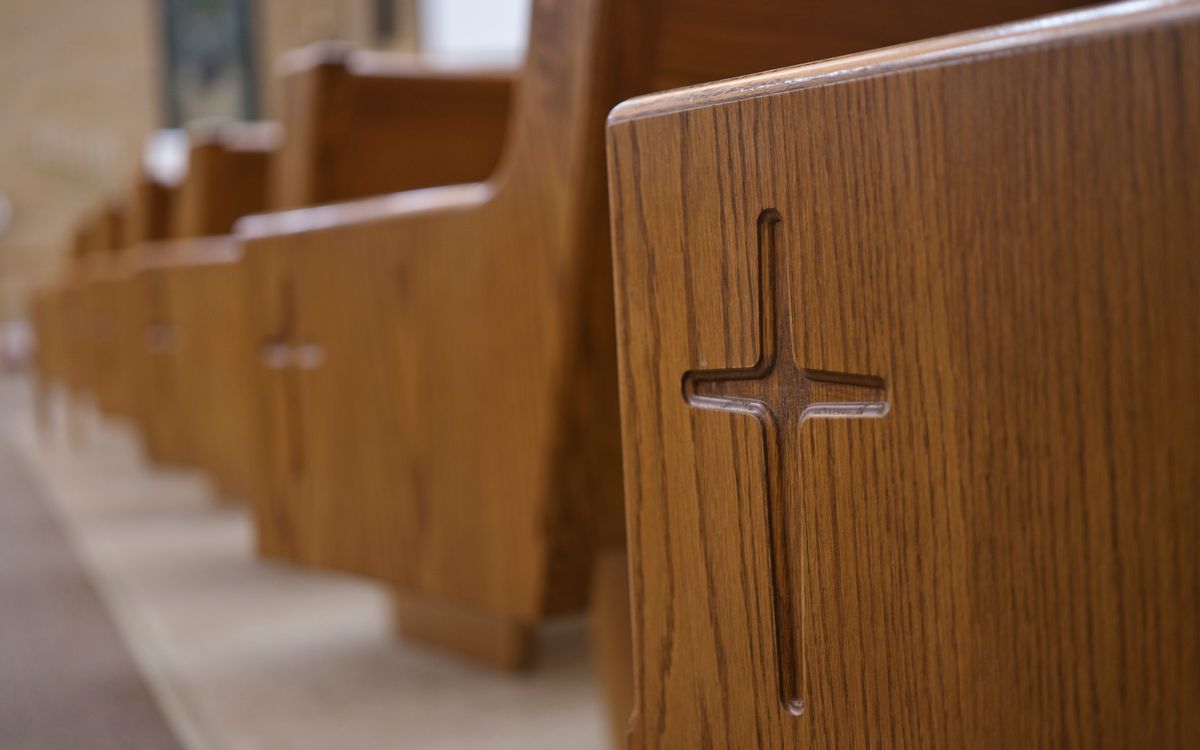 Detailed view of wooden church pews with cross carvings in a Berlin, Wisconsin church.