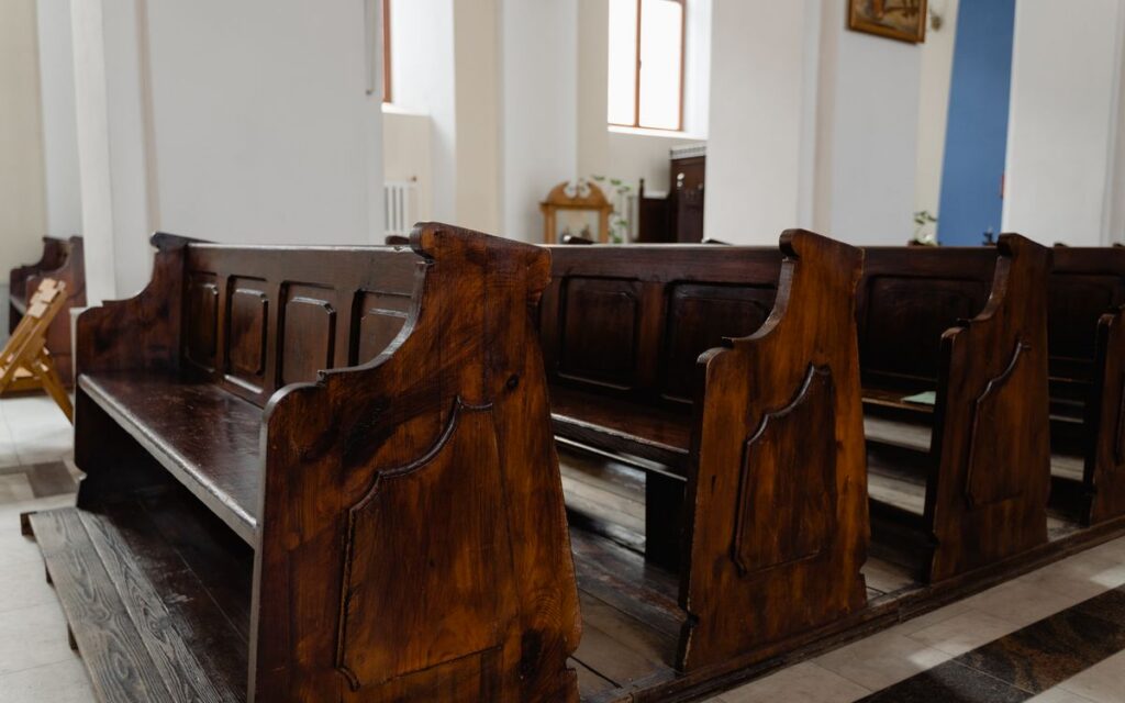 Quiet church interior featuring classic wooden pews, inviting reflection.