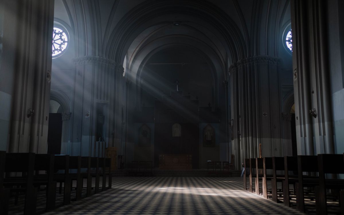 Gothic cathedral interior with sunrays illuminating the altar and arches, creating a peaceful ambiance.