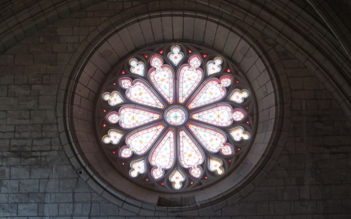 A beautiful circular stained glass window in a historic cathedral, showcasing intricate designs.