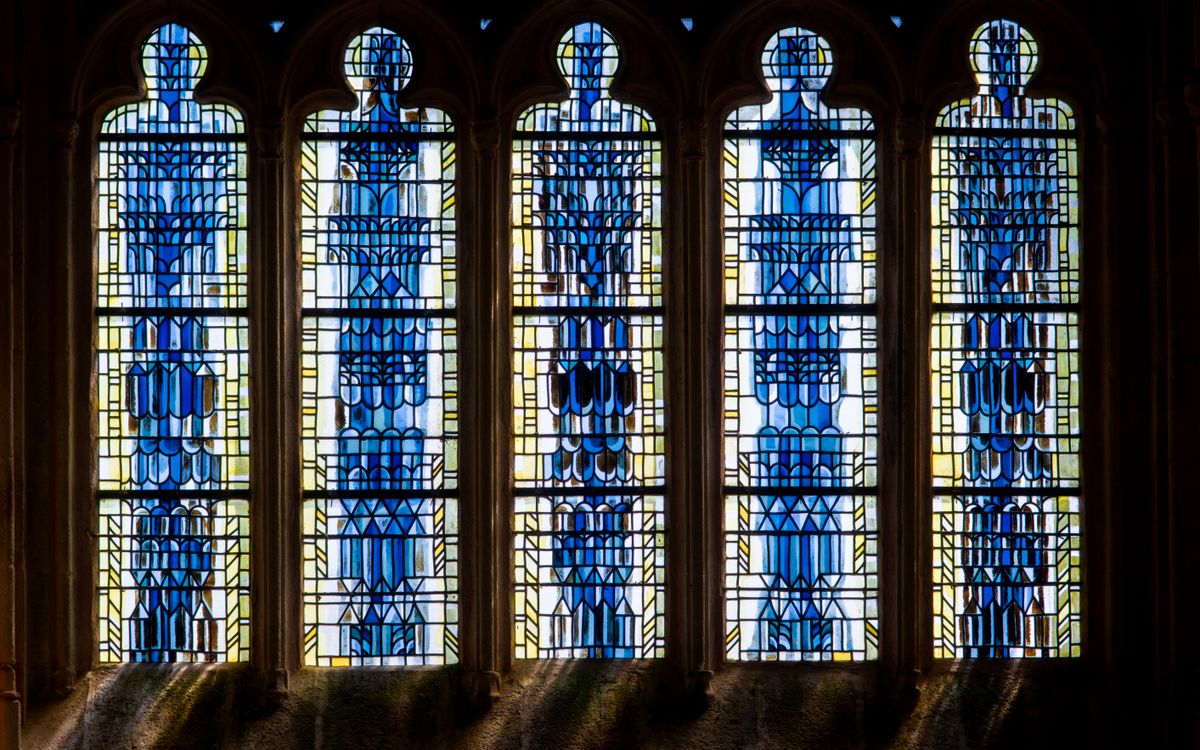 Beautiful stained glass windows featuring intricate blue patterns in a church interior.