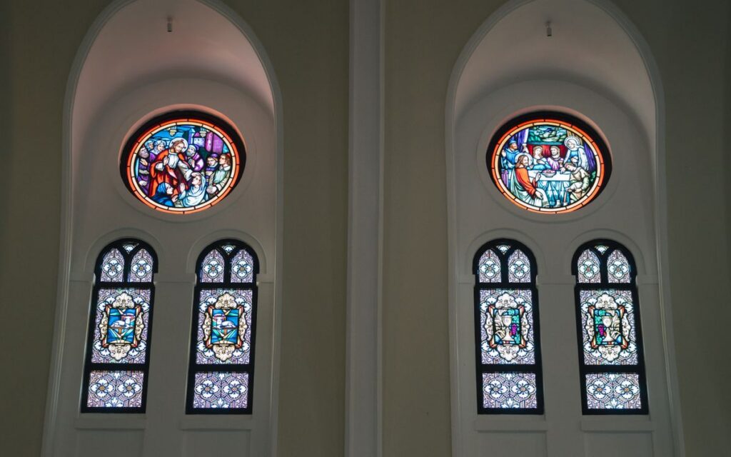 Interior view of a church featuring intricate stained glass windows depicting religious scenes.
