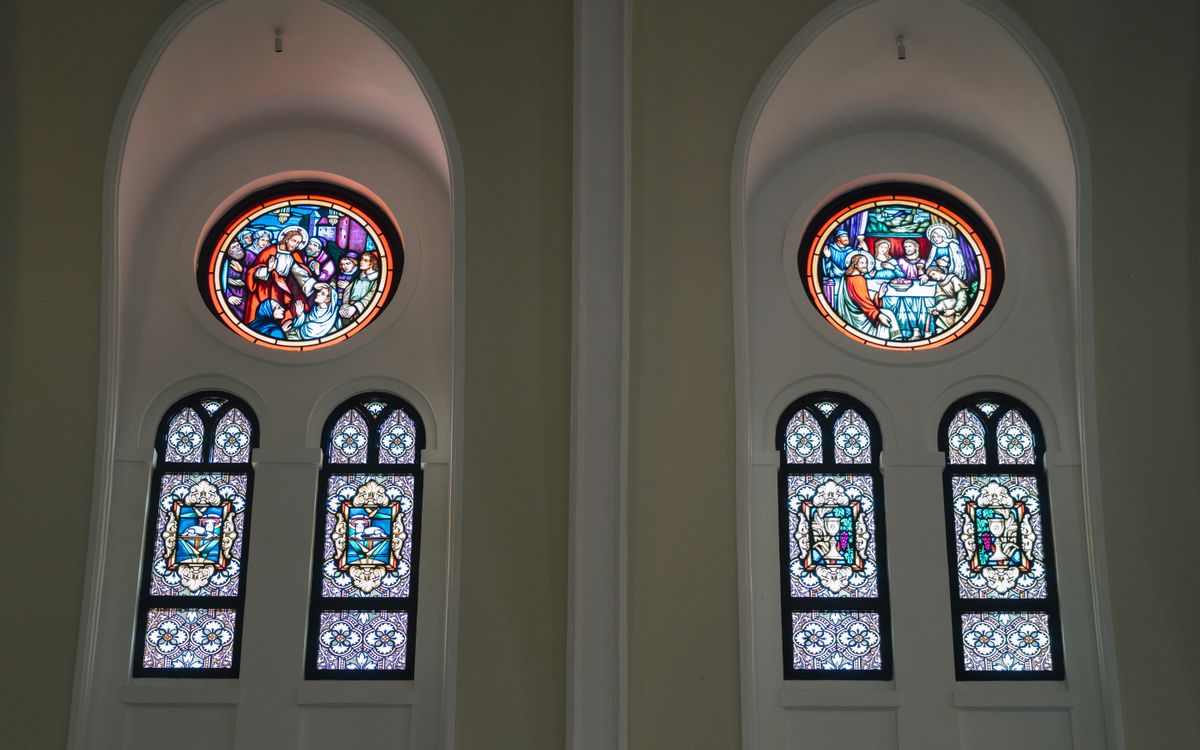 Interior view of a church featuring intricate stained glass windows depicting religious scenes.
