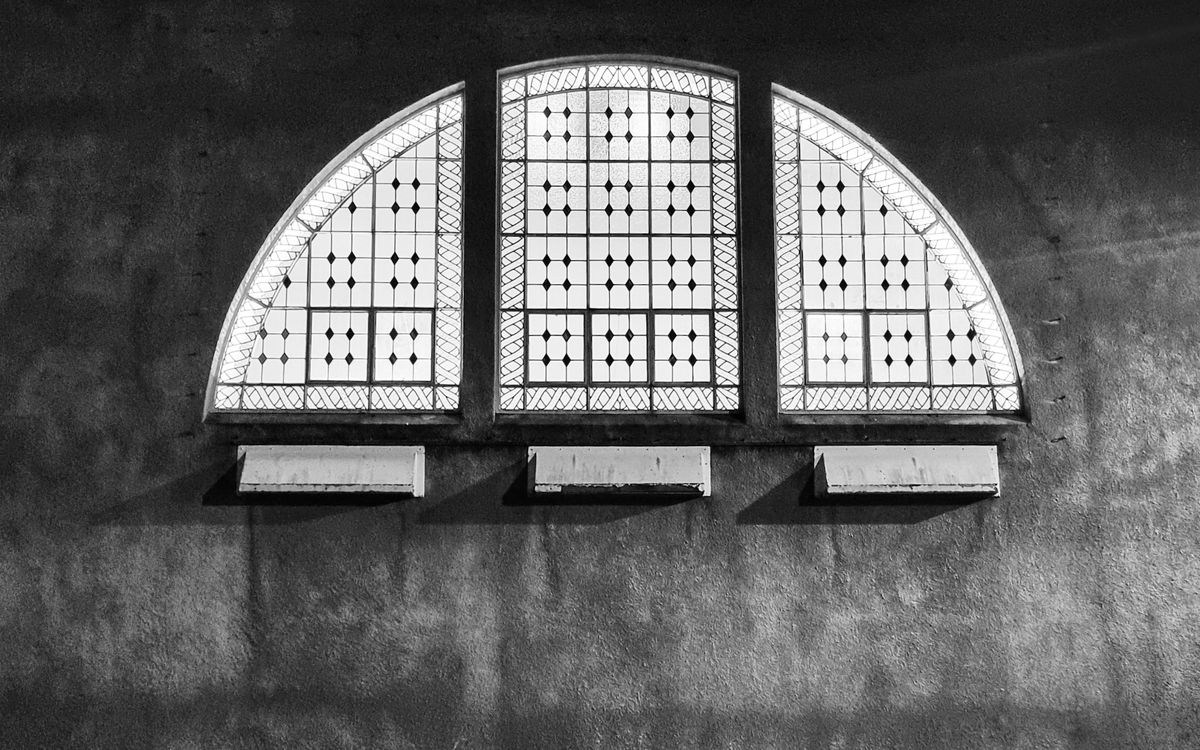 Elegant black and white image of a classic stained glass window with geometric patterns.