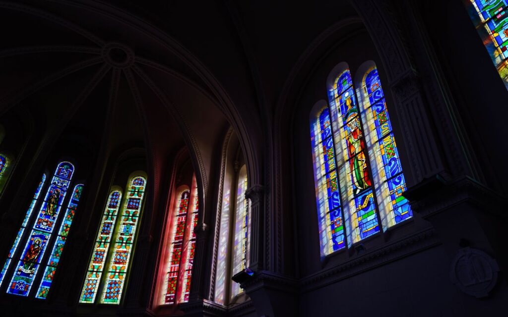 Vibrant stained glass windows inside a cathedral showcasing intricate religious art.