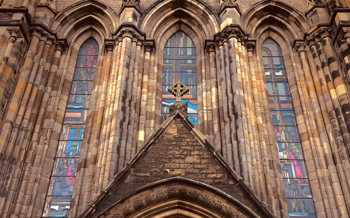 Close-up of Gothic architecture featuring ornate stained glass windows and intricate masonry details.