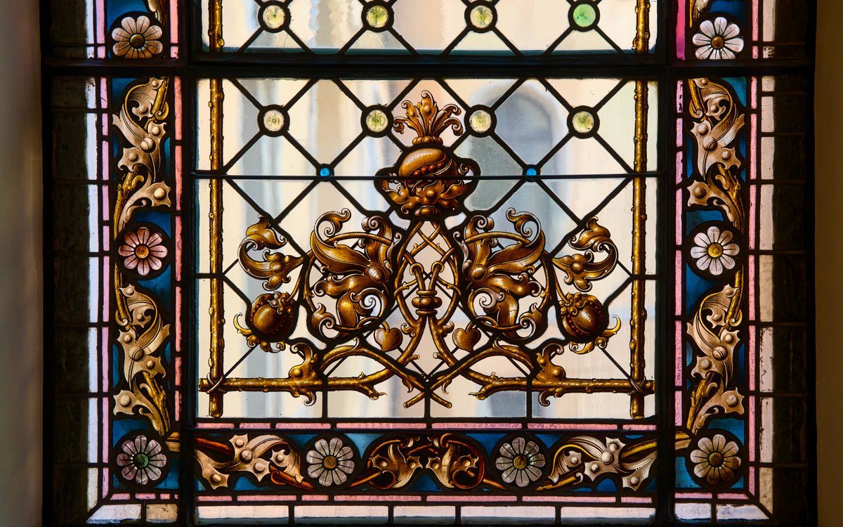 Detailed stained glass window with floral patterns in Zittau, Germany.