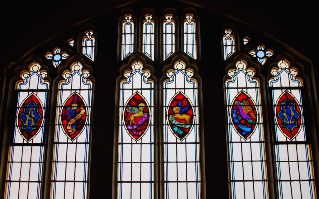 Vibrant stained glass windows featuring intricate designs in a church setting.