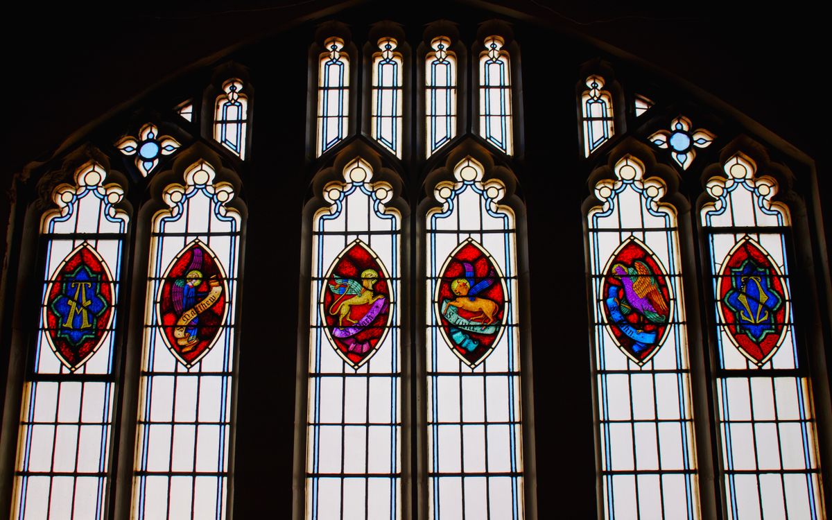 Vibrant stained glass windows featuring intricate designs in a church setting.