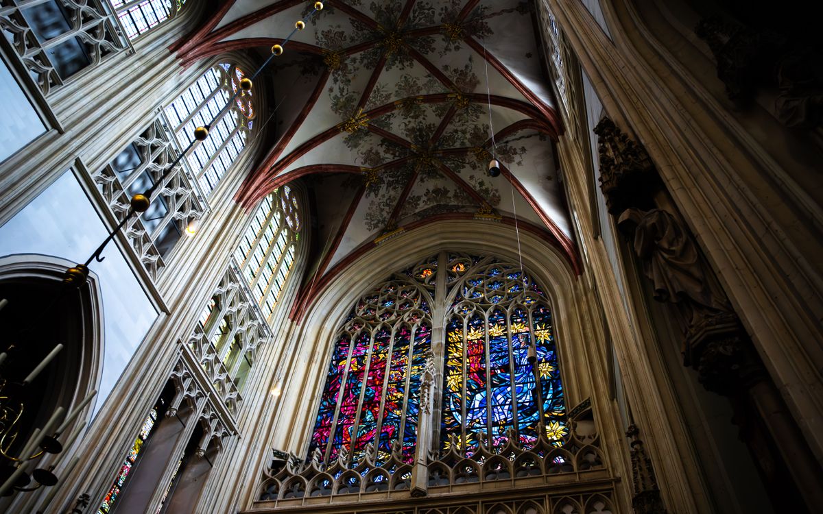 Stunning view of a Gothic cathedral ceiling and vivid stained glass windows.