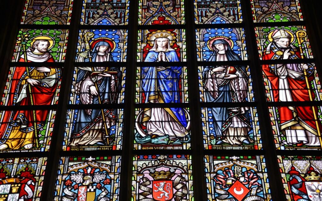 Colorful stained glass window depicting religious figures in a cathedral.