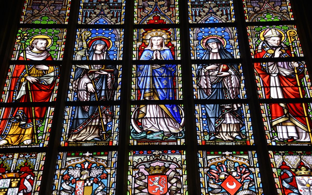 Colorful stained glass window depicting religious figures in a cathedral.