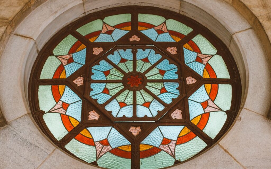 Intricate circular stained glass window featuring vibrant geometric patterns and vivid colors.