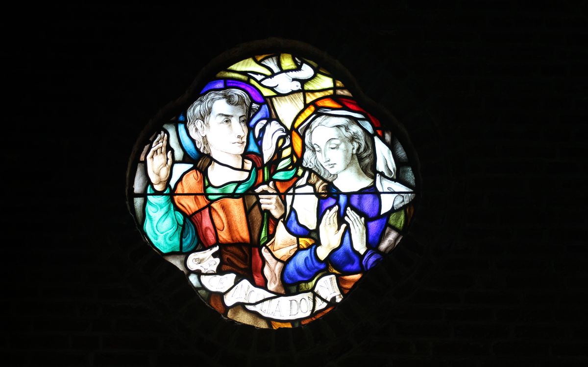 Vibrant stained glass window depicting religious figures in a Dutch church.