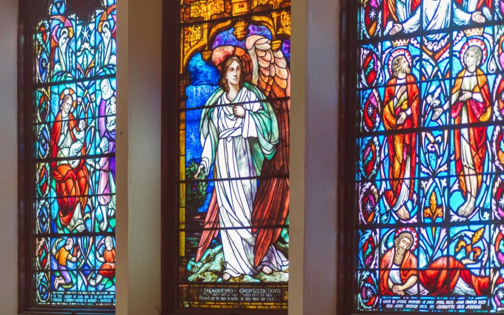 Vibrant stained glass windows depicting religious figures in a church setting.