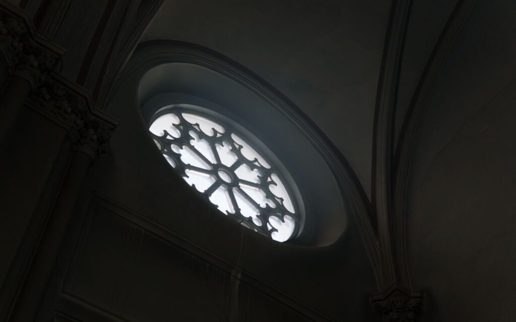 Low-angle view of a Gothic cathedral window showcasing intricate design and natural light.